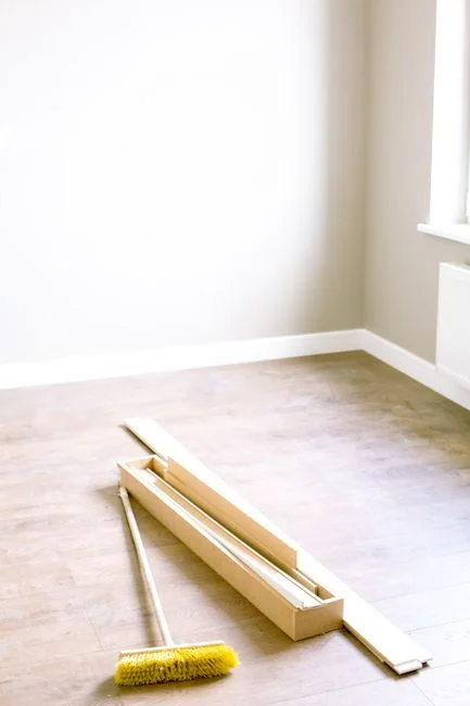 who-we-are A man in coveralls cleans a large window in a stylish, modern home interior.